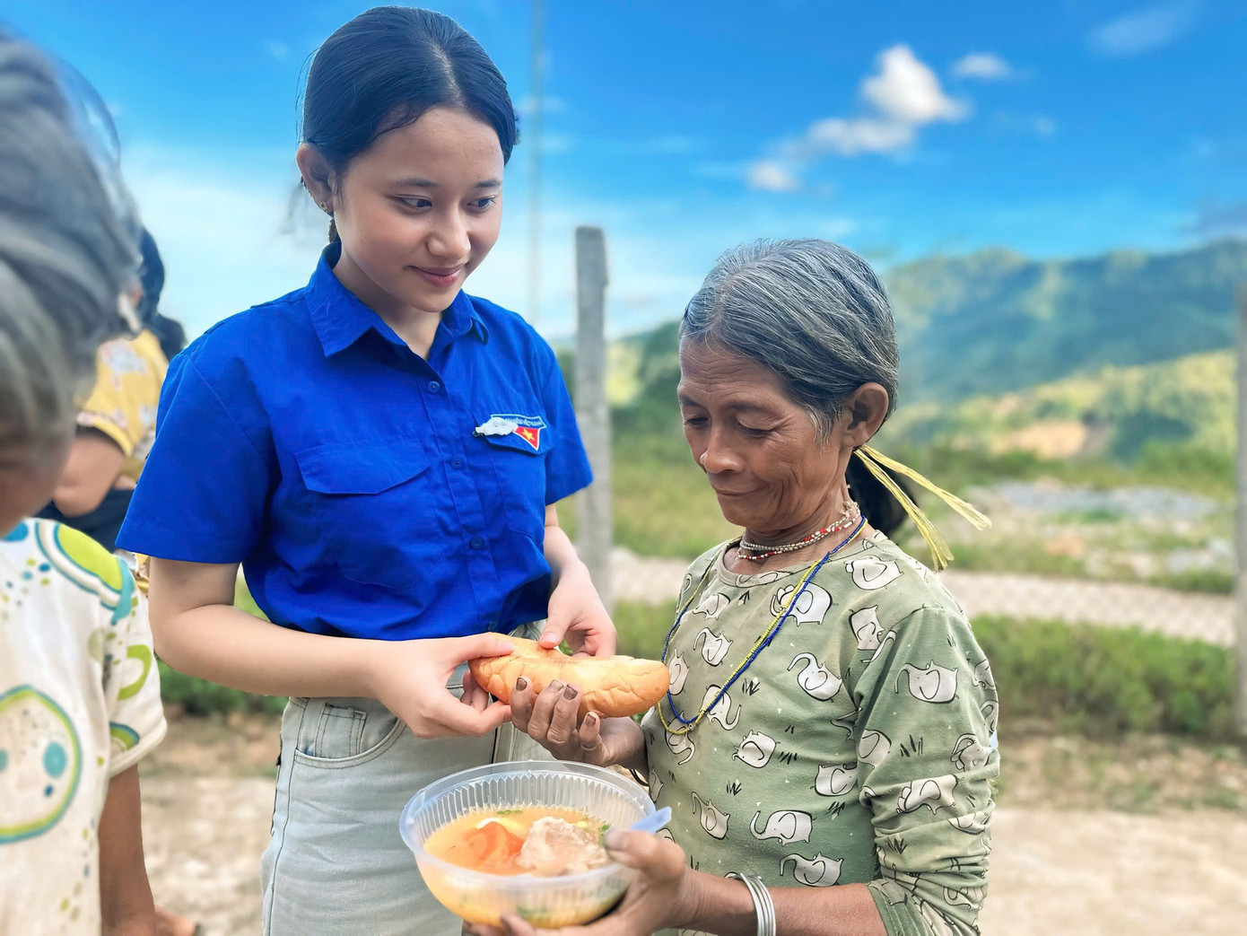 Các tình nguyện viên mời từng em nhỏ, bà con trong làng thưởng thức.
