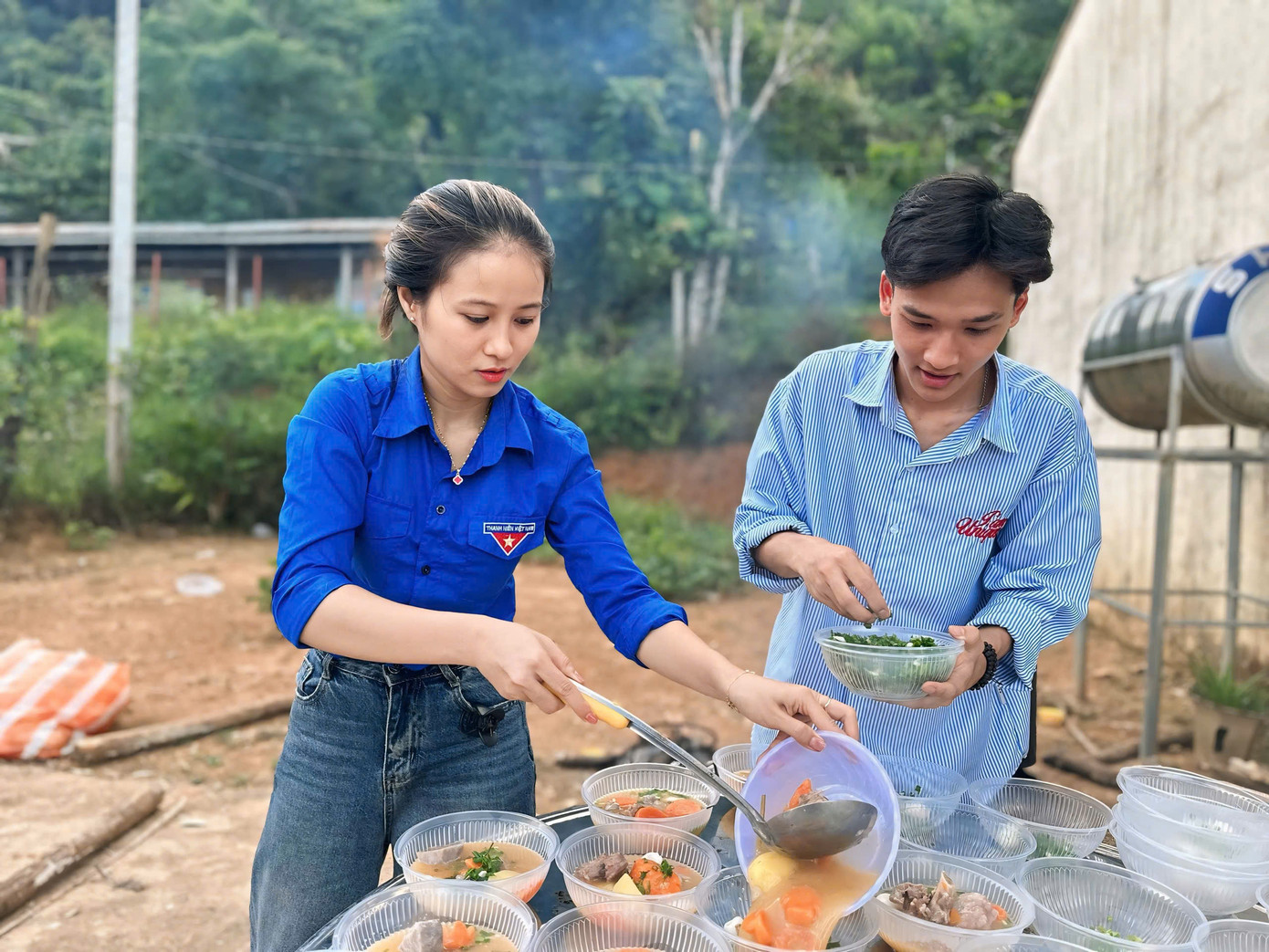 Các tình nguyện viên mời từng em nhỏ, bà con trong làng thưởng thức.