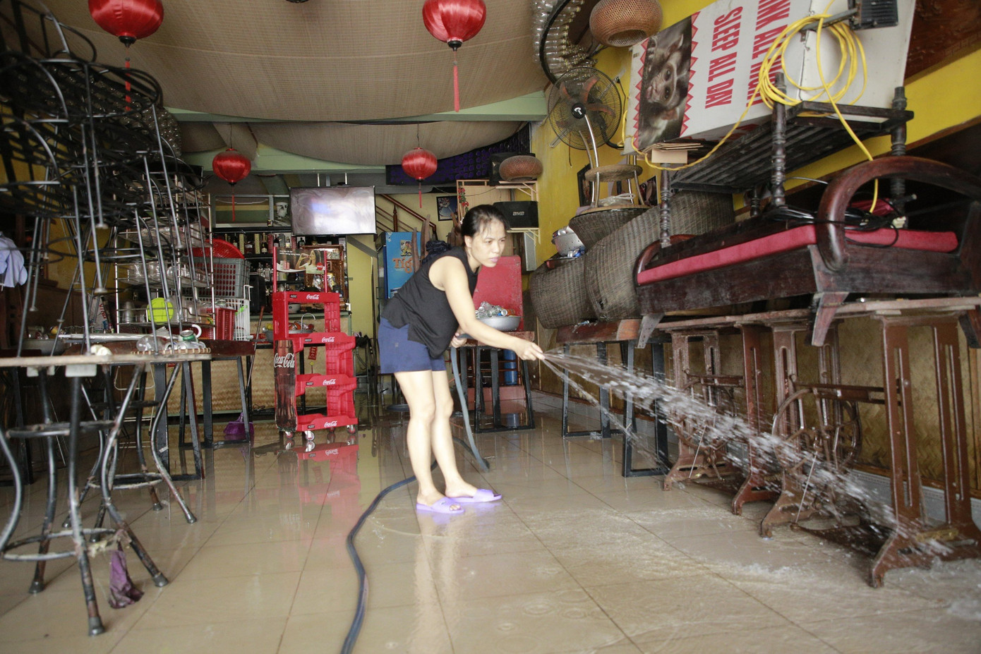 Sau nhiều giờ đồng hồ nước lũ &quot;cố thủ&quot; trong nhà đến chiều tối nay nước bắt đầu rút để lại lớp bùn non. Người dân Hội An dùng chổi, xối nước đẩy lớp bùn khỏi bết dính trong nhà và dưới lòng đường.