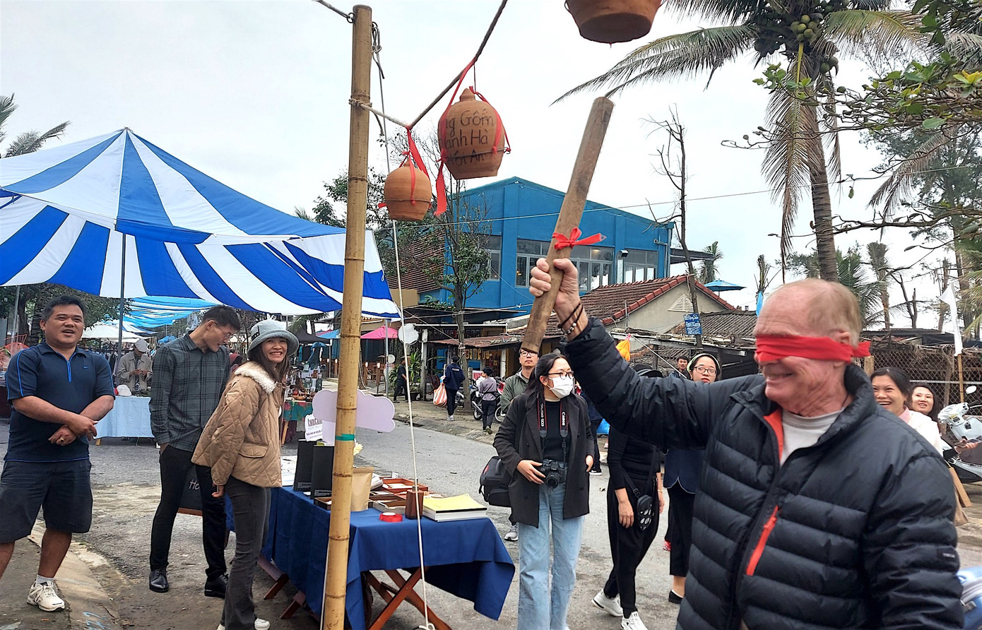 Khách tây hào hứng tham gia trò chơi dân gian bịt mắt đập niêu. Ảnh Hoài Văn Khách tây hào hứng tham gia trò chơi dân gian bịt mắt đập niêu. Ảnh Hoài Văn