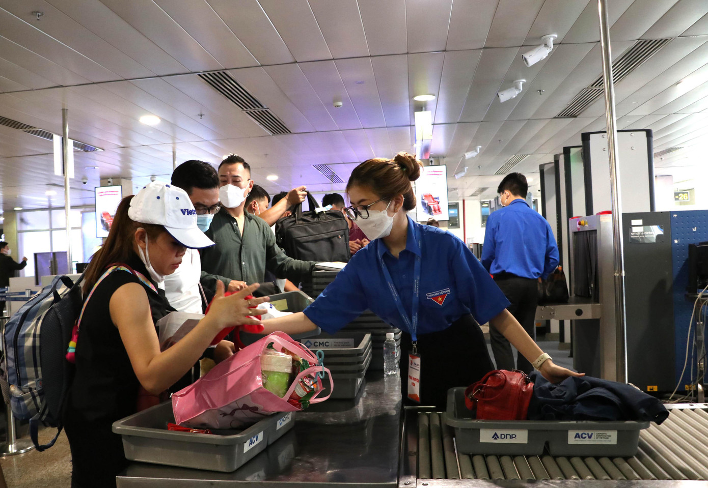 Tình nguyện viên hướng dẫn hành khách làm thủ tục kiểm tra an ninh sáng 28/4.