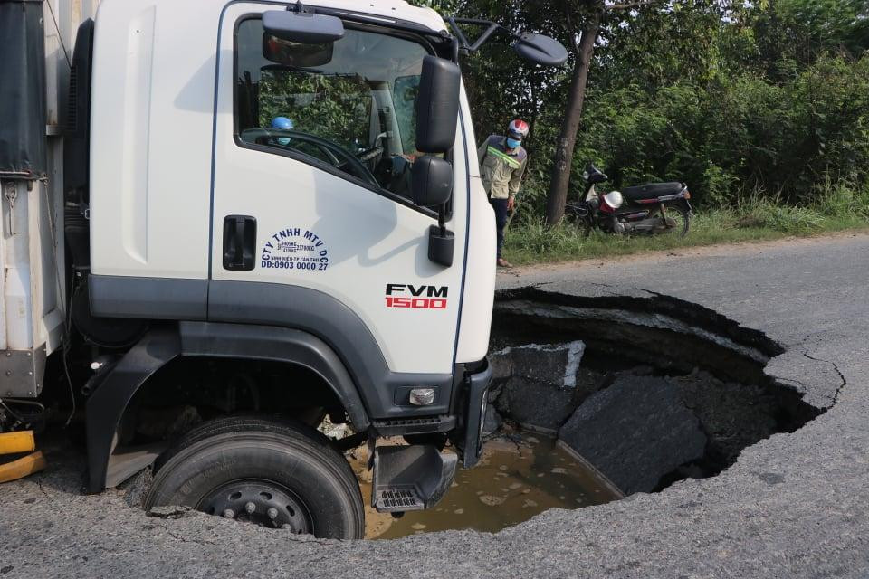 Hai bánh trước xe tải lọt hố tử thần.