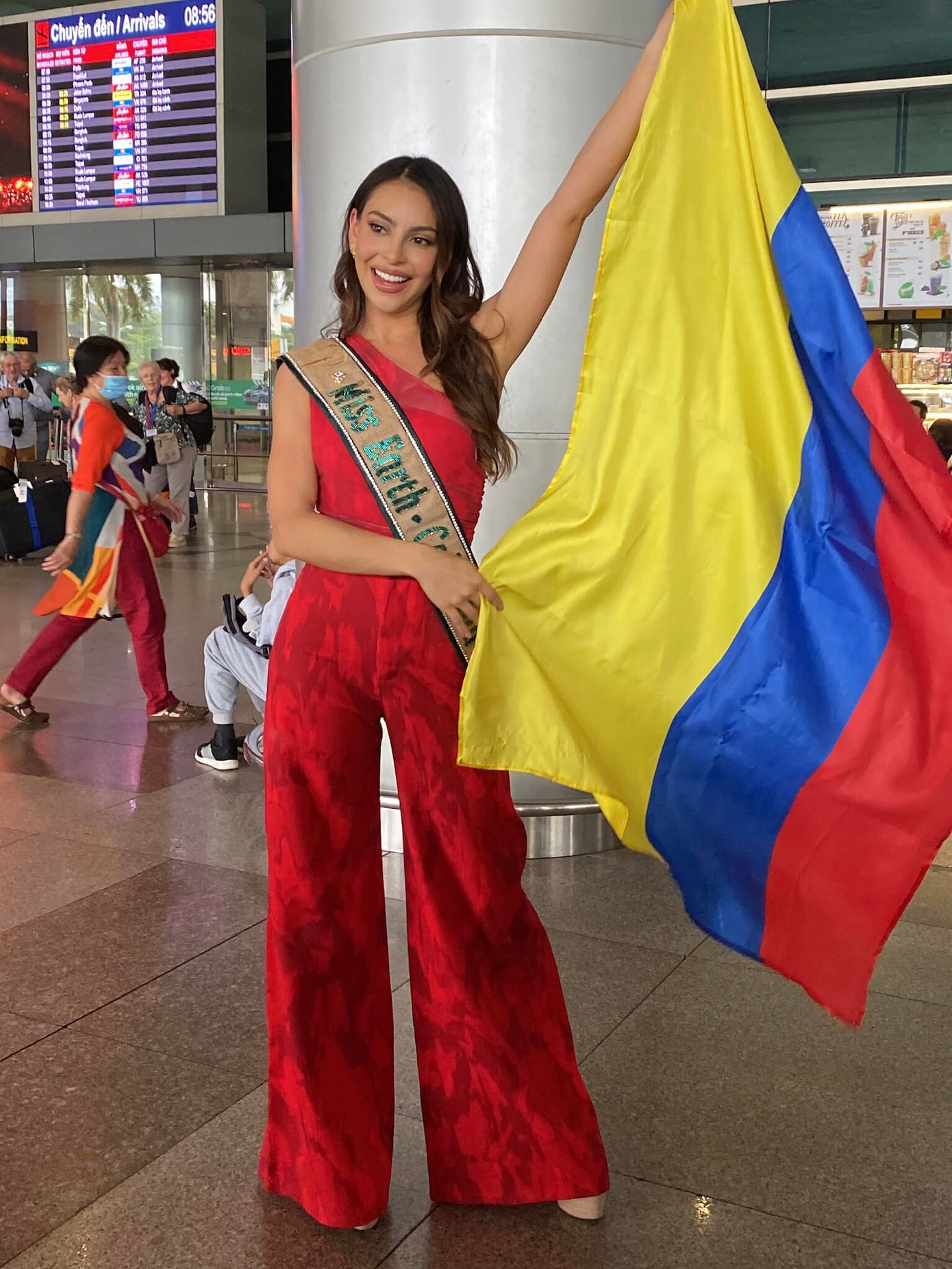 Người đẹp Colombia rạng rỡ ở sân bay Tân Sơn Nhất. Cô diện bộ jumpsuit màu đỏ nổi bật. Người đẹp là một trong những ứng viên mạnh của khu vực Mỹ Latinh, nhận được sự ủng hộ nhiệt tình từ người hâm mộ.