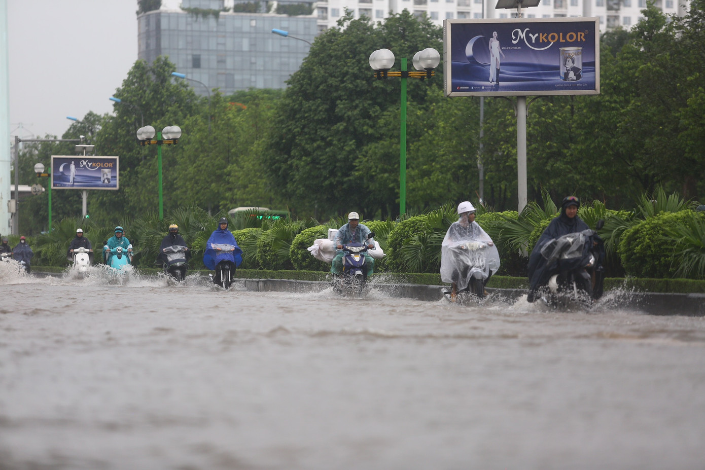 Các phương tiện chỉ có thể di chuyển thành một hàng sát dải phân cách để vượt khu vực ngập úng.