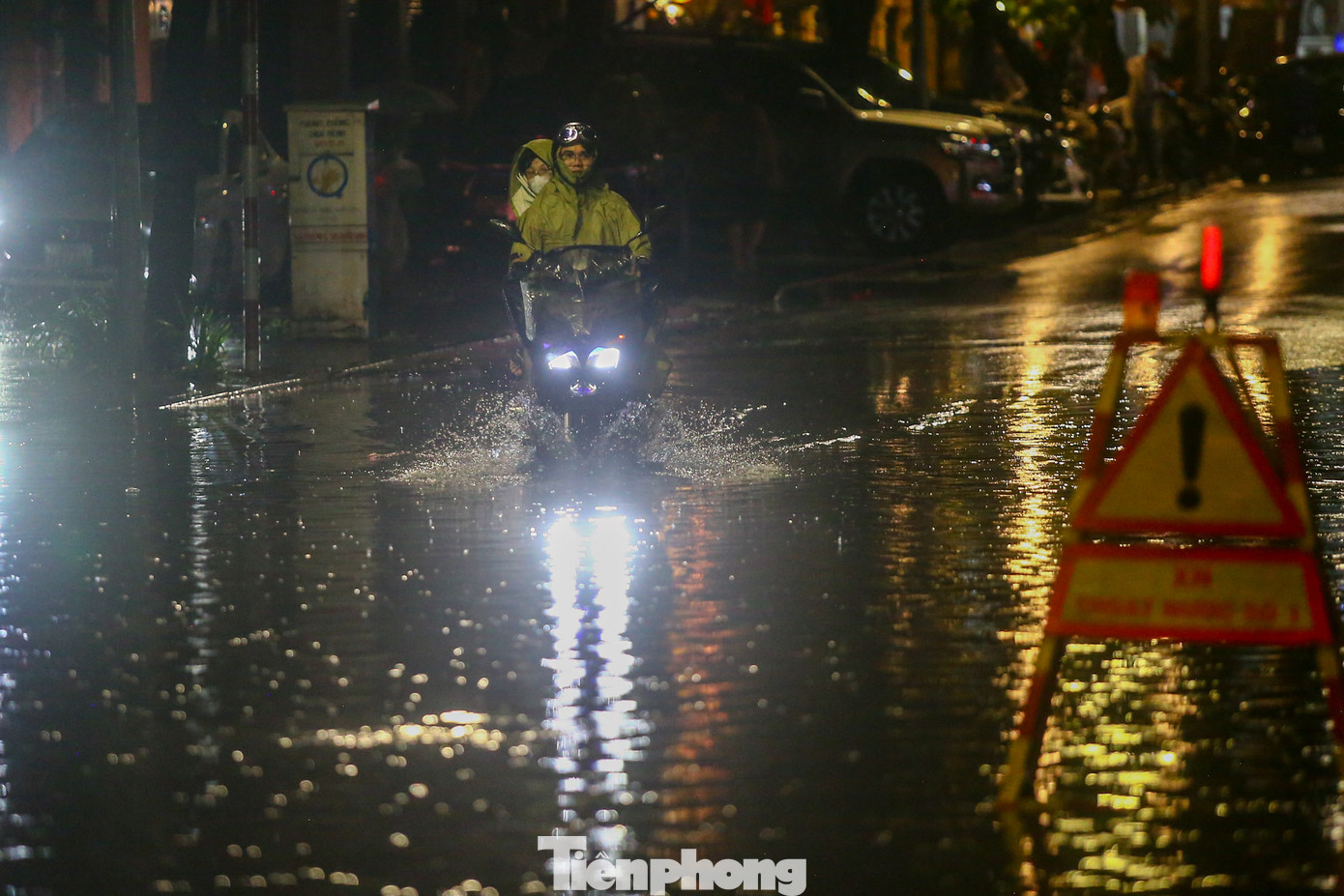 Khoảng 21h ngày 8/6, nước vẫn chưa rút hết trên phố; các phương tiện chỉ có thể di chuyển chậm qua khu vực bị ngập.