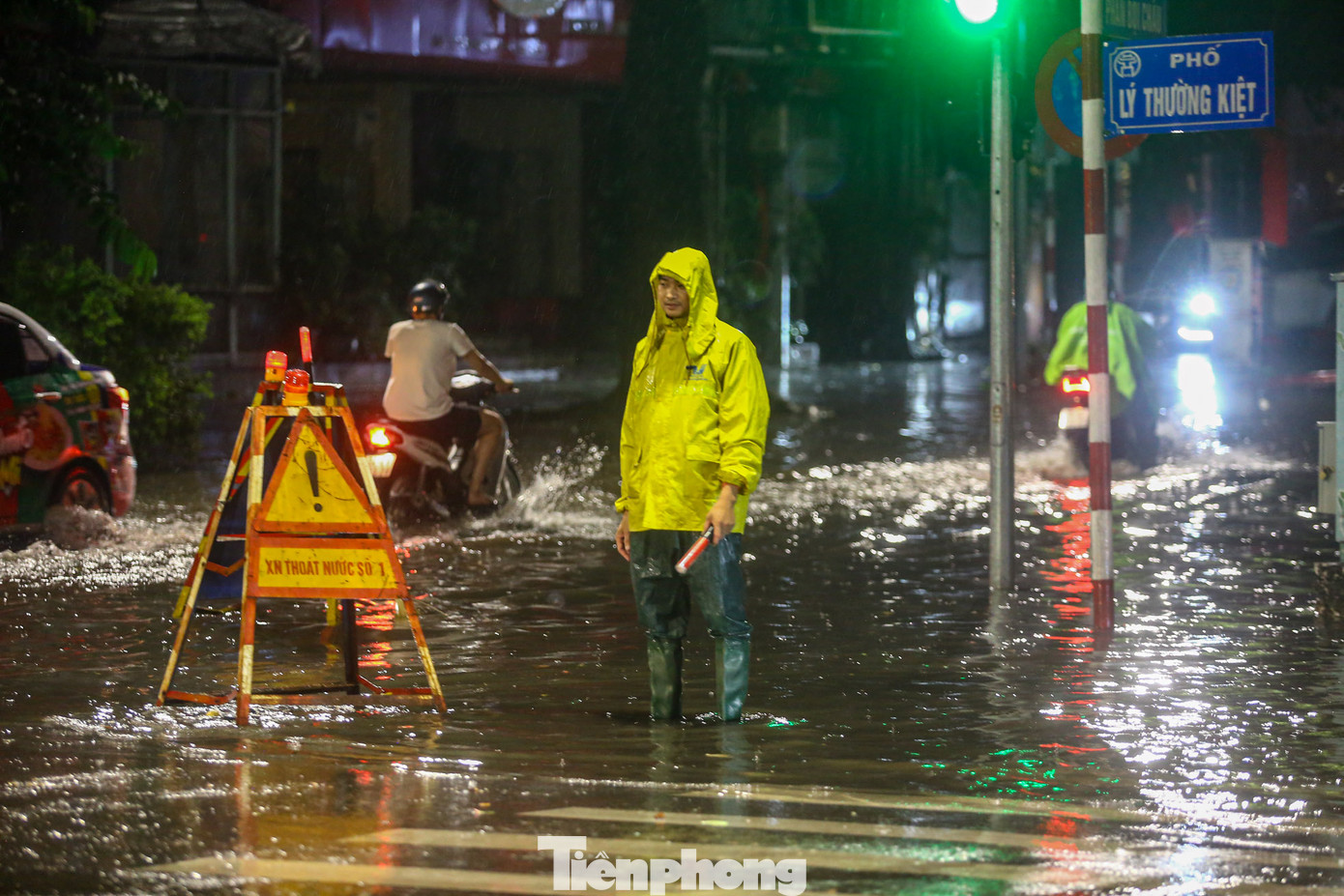 Cơn mưa trút nước khiến ngã tư Lý Thường Kiệt - Phan Bội Châu chìm trong biển nước. Nhân viên thoát nước cắm biển báo nguy hiểm tại khu vực này.