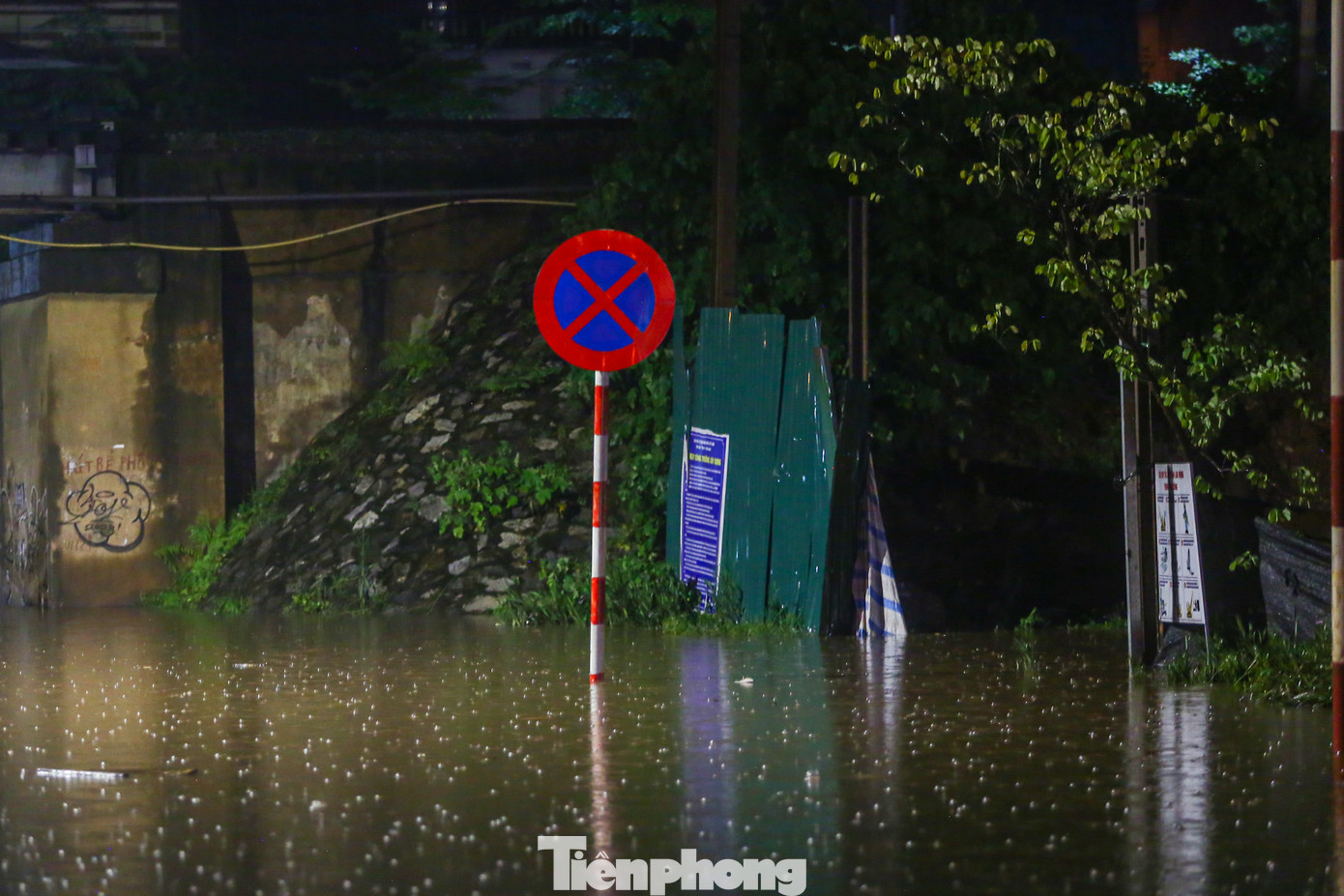 Nước ngập sâu tràn vào nhà hai bên đường, không còn thấy vỉa hè.