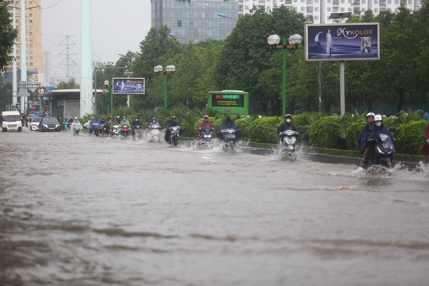 Các phương tiện chỉ có thể di chuyển thành một hàng sát dải phân cách để vượt khu vực ngập úng.