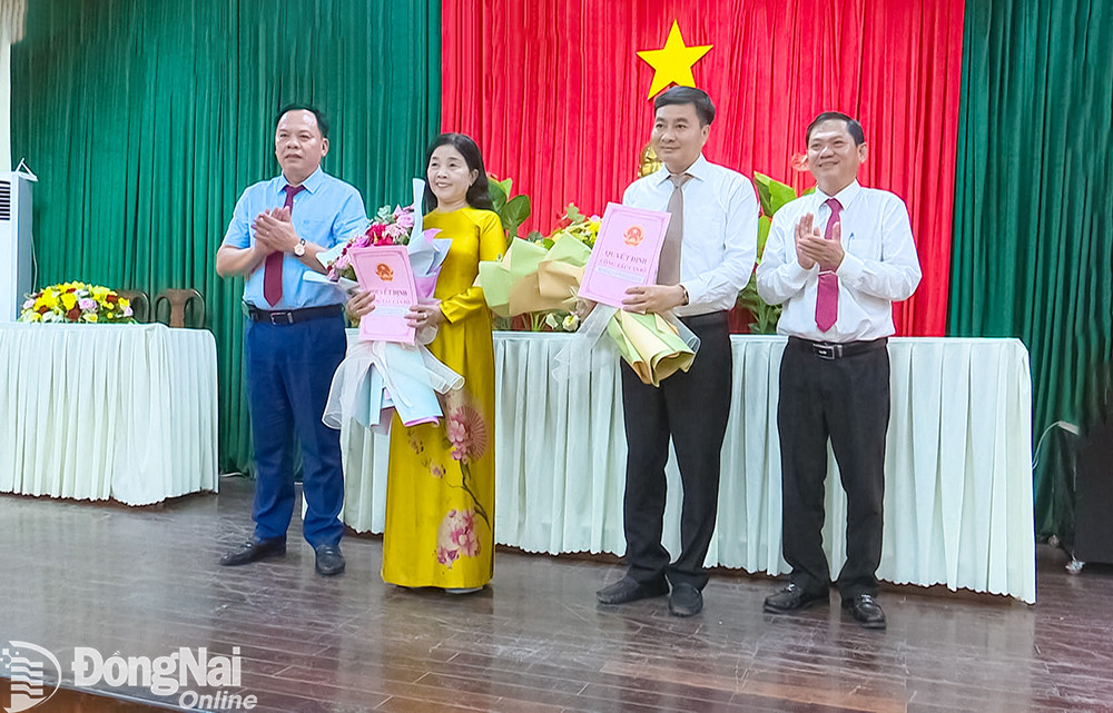 Quyền Chủ tịch UBND tỉnh Đồng Nai Võ Tấn Đức (ngoài cùng bên trái) trao quyết định về công tác cán bộ và Bí thư Huyện ủy Trảng Bom Lê Tuấn Anh tặng hoa cho bà Vũ Thị Minh Châu và ông Lê Ngọc Tiên. Ảnh: H.Thảo