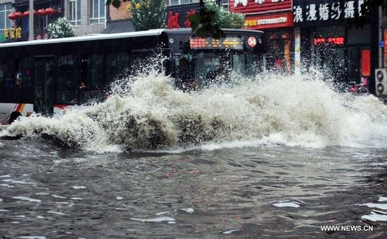 Một chiếc xe buýt di chuyển trên đường phố ngập nước tại quận 