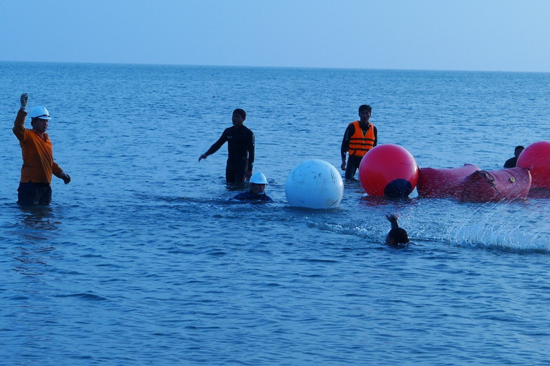 Đầu cáp mới cắt sẽ được nối dây tời để kéo vào bờ bằng canô và cáp tời từ đất liền. Trong quá trình kéo, các kỹ sư luôn phải bám sát để điều chỉnh hướng đi của đầu cáp