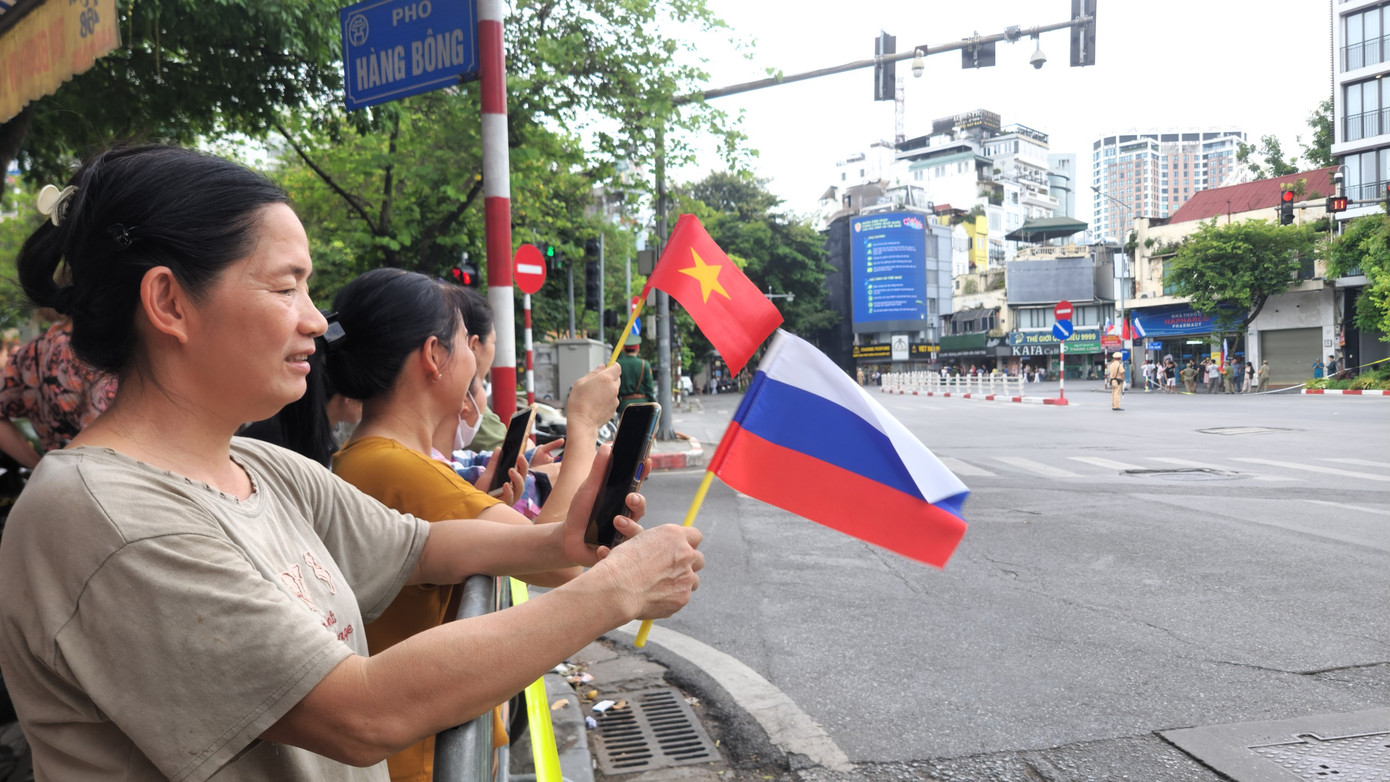 Người dân Hà Nội cầm cờ Việt Nam và Nga chờ đón đoàn xe chở Tổng thống Putin đi qua. (Ảnh: Phạm Duy) Người dân Hà Nội cầm cờ Việt Nam và Nga chờ đón đoàn xe chở Tổng thống Putin đi qua. (Ảnh: Phạm Duy)