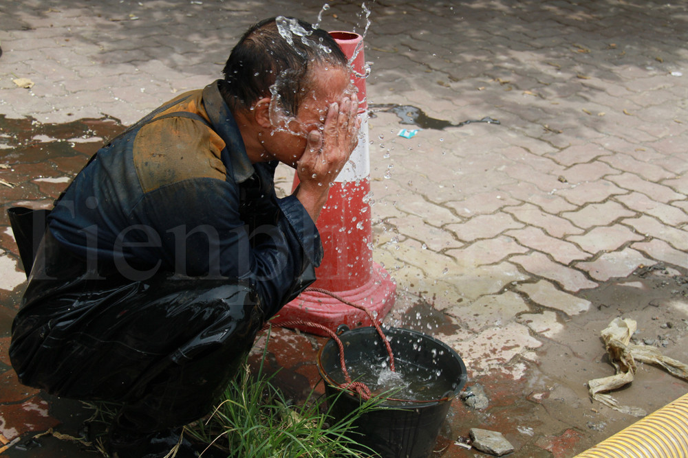 Anh Sơn rửa mặt sau một ngày làm việc vất vả dưới cống ngầm. Ảnh: Trường Phong