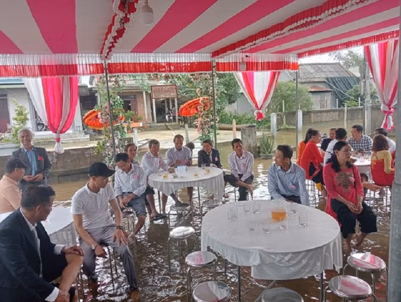 Khách mời lội lụt đến nhà chú rể chúc phúc. Ảnh: CTV