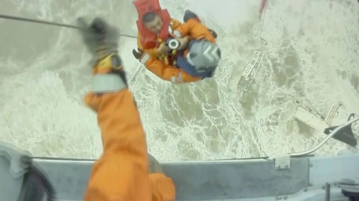 Một thủy thủ được cứu và đưa lên trực thăng. Ảnh: Reuters