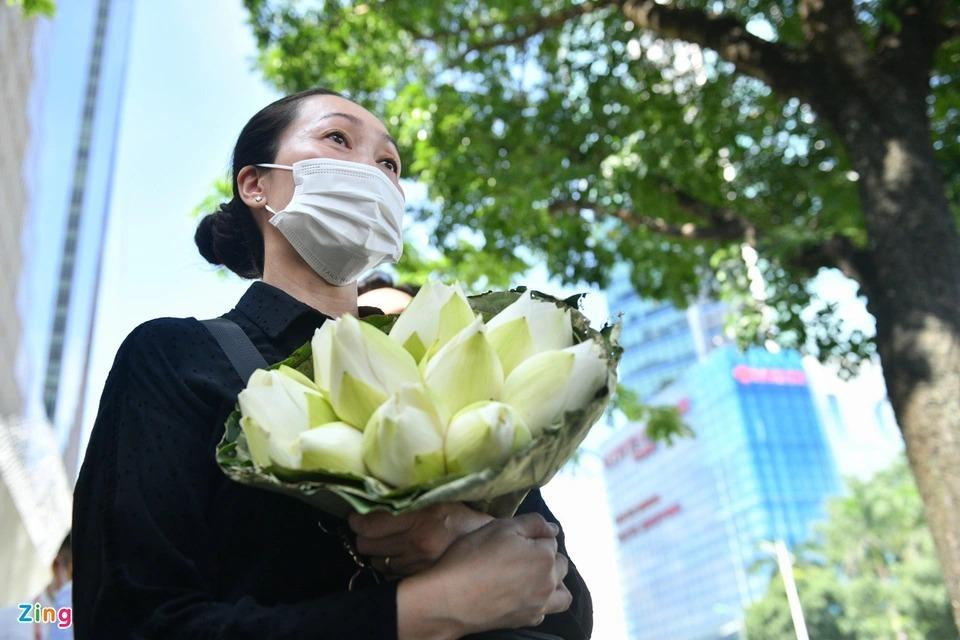 Nhiều người mang theo hoa tươi, mặc đồ đen đứng xếp hàng bên ngoài Đại sứ quán. Phần lớn những người tới ghi sổ tang trong sáng 11/7 là những công dân Việt Nam từng có cơ hội sinh sống và làm việc tại Nhật Bản hoặc các doanh nghiệp, du học sinh...