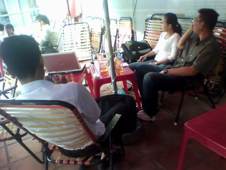 Nhân viên Công ty Vietland (trái) cố gắng thuyết phục khách hàng ký hợp đồng thu phí môi giới giá từ 500.000 đồng - 1.000.000 đồng tại quán cà phê vỉa hè