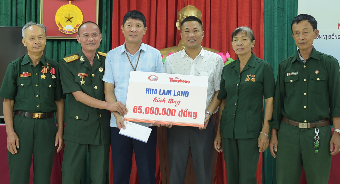 Ông Nguyễn Huy Thiêm - Giám đốc truyền thông Công ty CP Kinh doanh địa ốc Him Lam (thứ ba từ phải sang) trao biển quà tặng tới Trung tâm Chăm sóc, nuôi dưỡng người có công tỉnh Thanh Hóa. Ảnh: Xuân Tùng