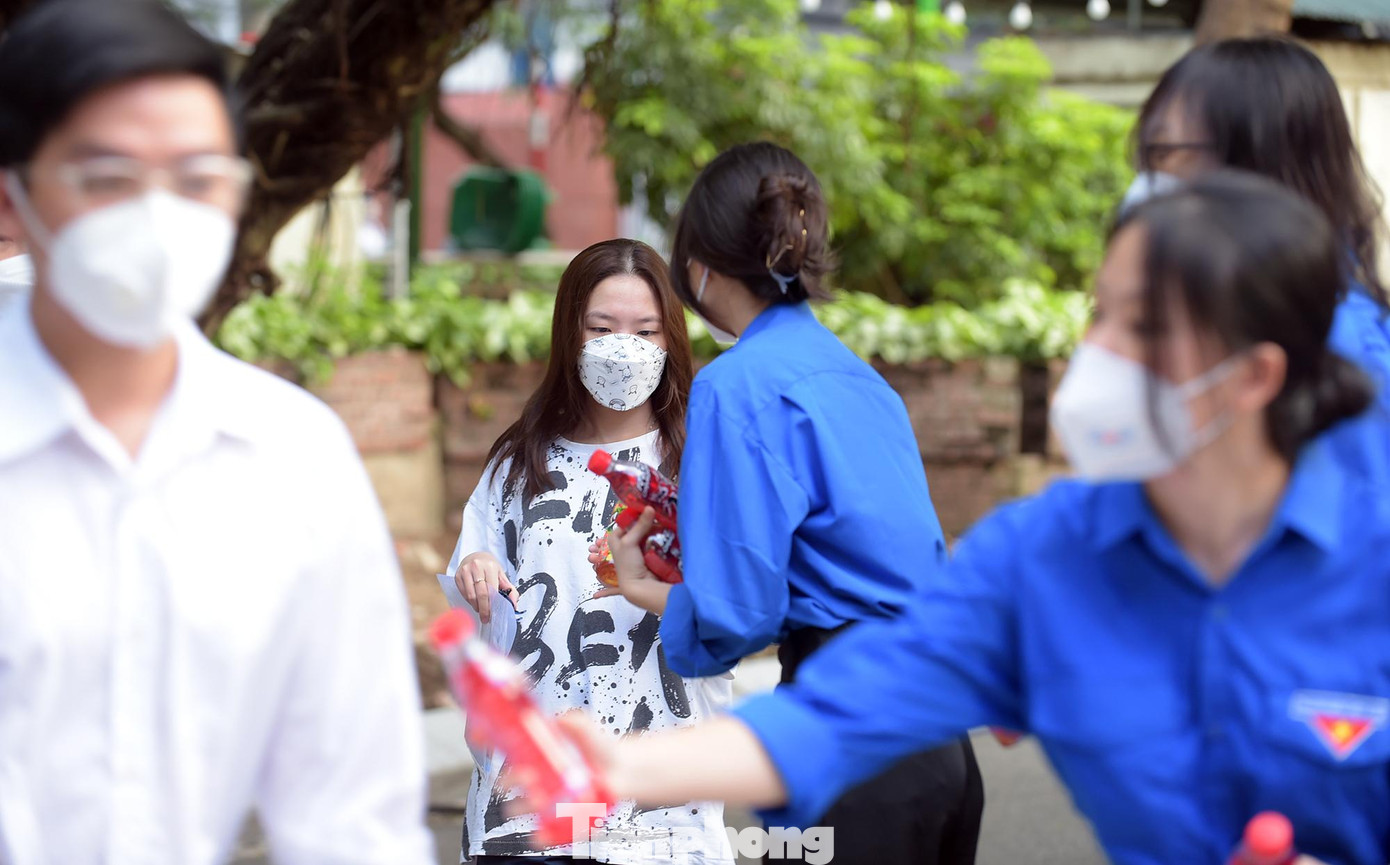 Bên cạnh việc tham gia phân luồng giao thông, hướng dẫn thí sinh vào phòng thi..., các tình nguyện viên trao nước uống miễn phí tới thí sinh. Ảnh: Xuân Tùng