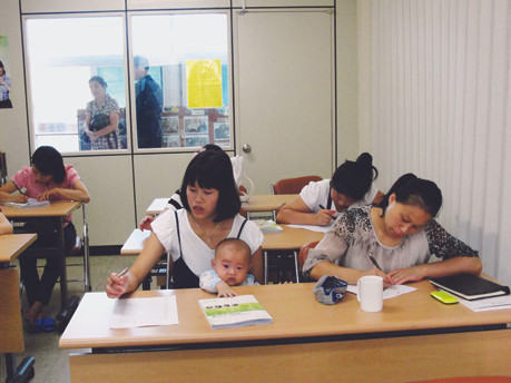 Ánh (bế con trai 5 tháng tuổi) học tiếng Hàn cùng các cô dâu Việt khác Ảnh: Th.Hà