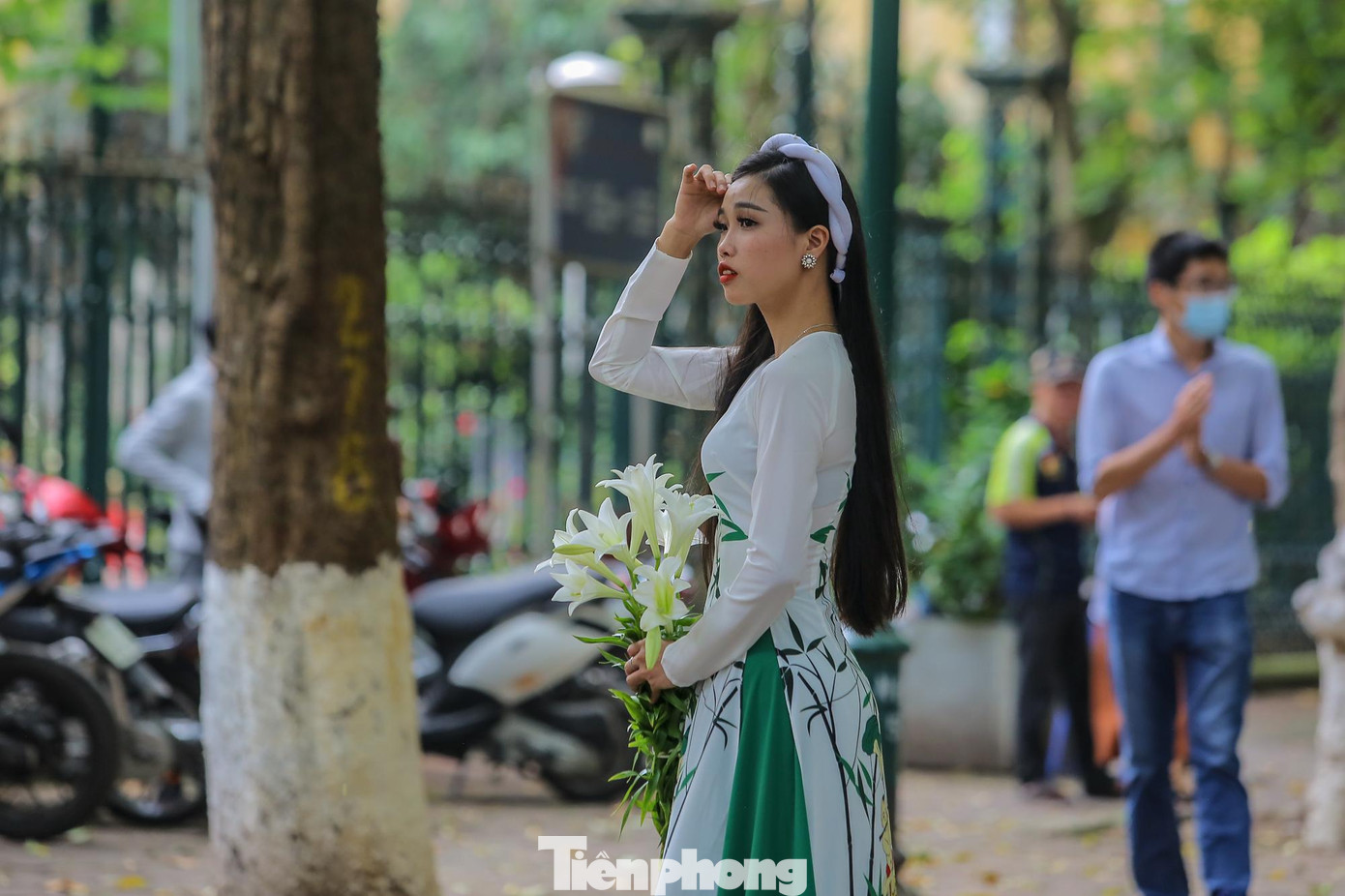 Thiếu nữ thả dáng với áo dài thướt tha cùng hoa loa kèn.