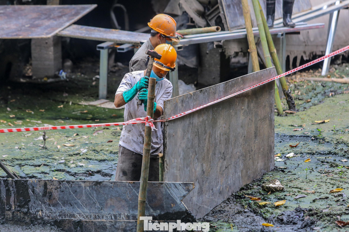 Công nhân đang quây dàn giáo bằng cọc tre bao quanh mảnh xác máy bay B52 để bảo dưỡng. Công nhân đang quây dàn giáo bằng cọc tre bao quanh mảnh xác máy bay B52 để bảo dưỡng.