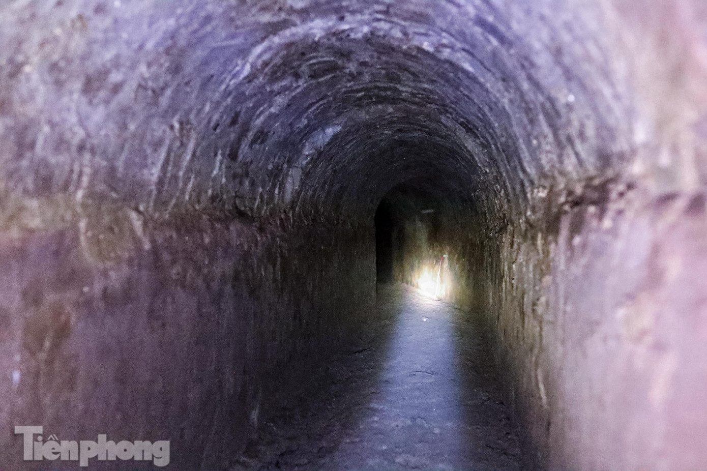 Một đoạn địa đạo, tường được xây bằng gạch, trần uốn cong kiểu mái vòm.