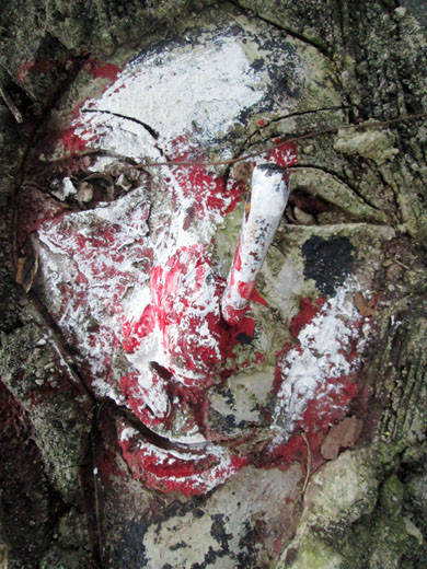 Một tượng mặt người bị cắm dao đầy máu me