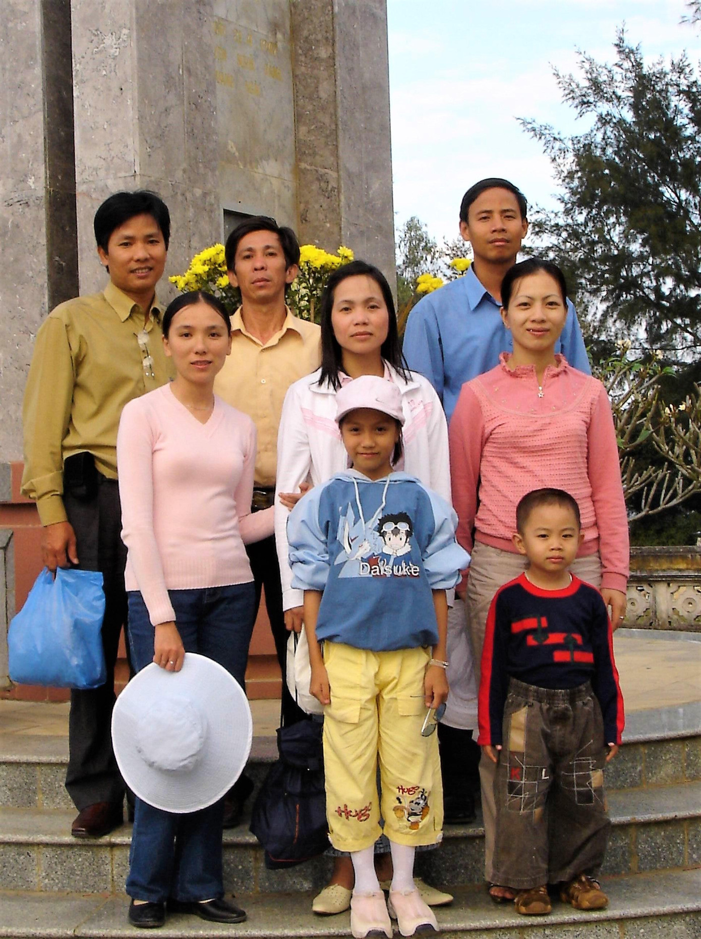 Quỳnh Trang (bé gái đứng giữa) ở tuổi lên 10 và tác giả đứng ở rìa trái. Ảnh chụp mùng 3 Tết, tức ngày 11/2/2005, trước mộ cụ Huỳnh Thúc Kháng trên núi Thiên Ấn, Quảng Ngãi (Ảnh tư liệu của tác giả).