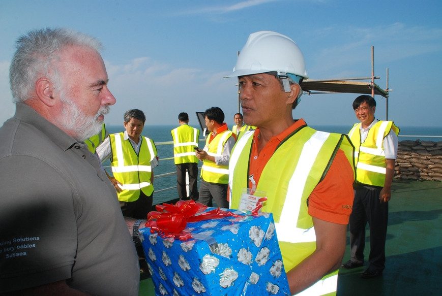 Ông Phạm Ngọc Lễ - phó Tổng giám đốc Công ty điện lực Miền Nam tặng quà cho các chuyên gia nước ngoài trên tàu Cable Enterprise