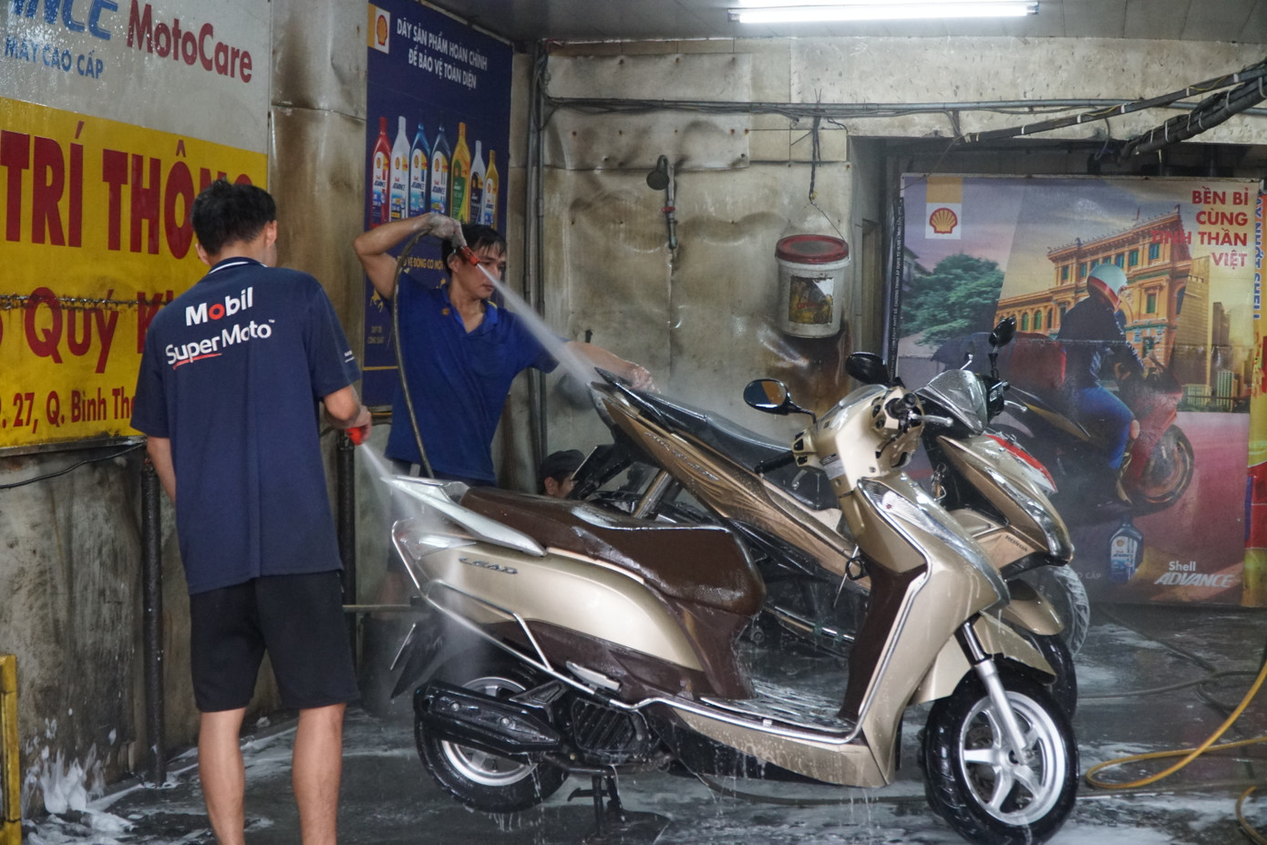 Ngoài dịch vụ rửa ô tô, nhiều tiệm rửa, thay nhớt xe máy cũng tấp nập khách những ngày giáp Tết.