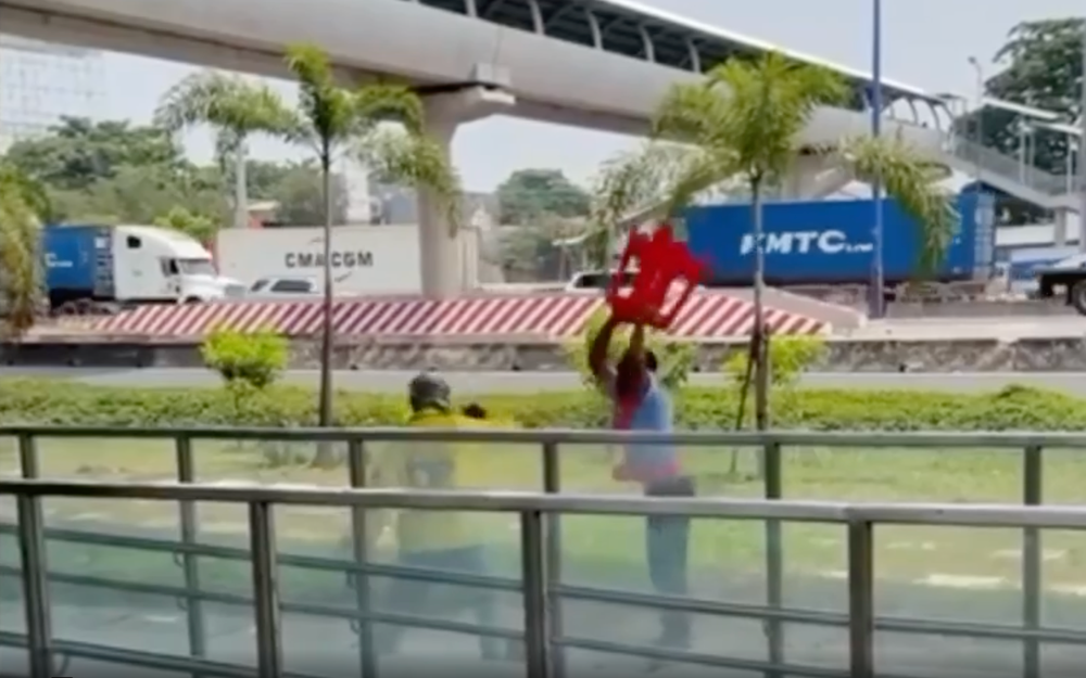 Nam bảo vệ nhà ga metro cầm ghế nhựa đánh nhau với tài xế xe ôm công nghệ vào trưa 22/3. Ảnh chụp từ video clip.