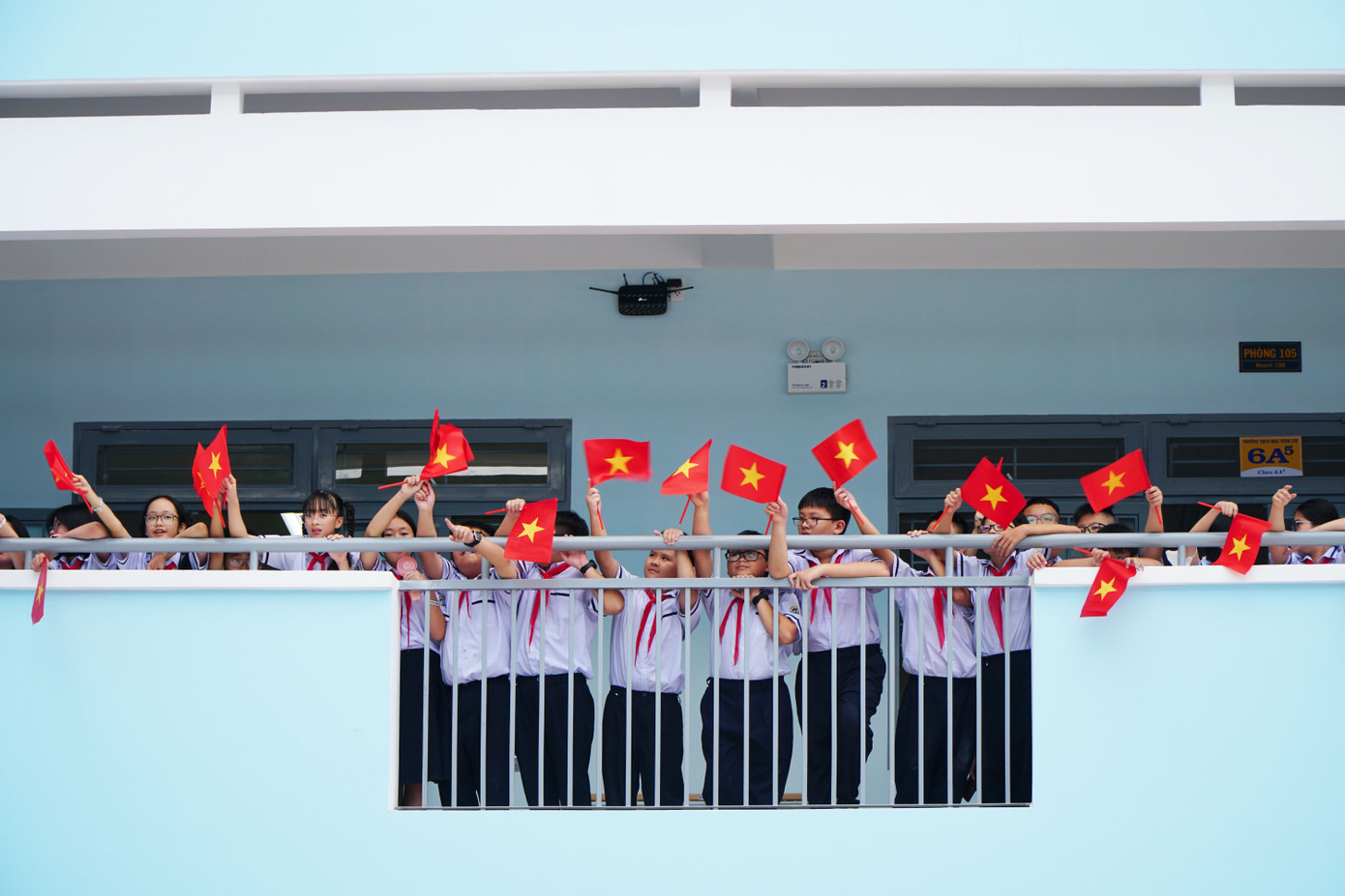 Trường lớp được trang trí rực rỡ cờ đỏ sao vàng. Nhiều học sinh Trường THCS Mạc Đĩnh Chi hò reo và vẫy cờ trong ngày trường được khánh thành, không khí tưng bừng như ngày hội.