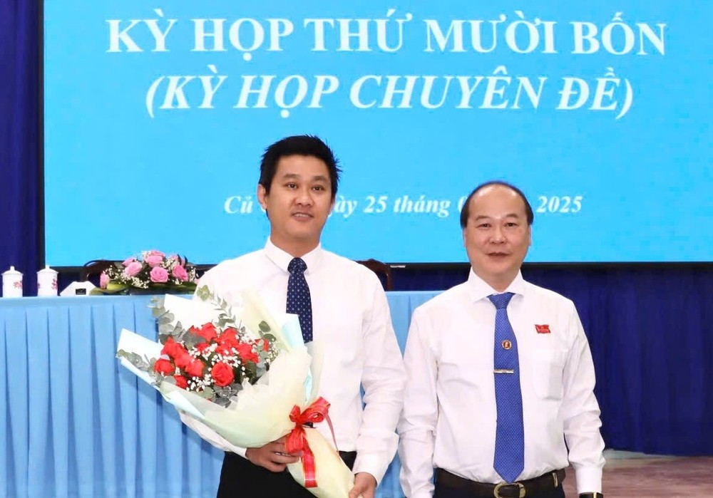 Bí thư Huyện ủy, Chủ tịch HĐND huyện Củ Chi Nguyễn Quyết Thắng (bên phải) tặng hoa chúc mừng ông Hứa Quốc Hưng được bầu làm Chủ tịch UBND huyện.