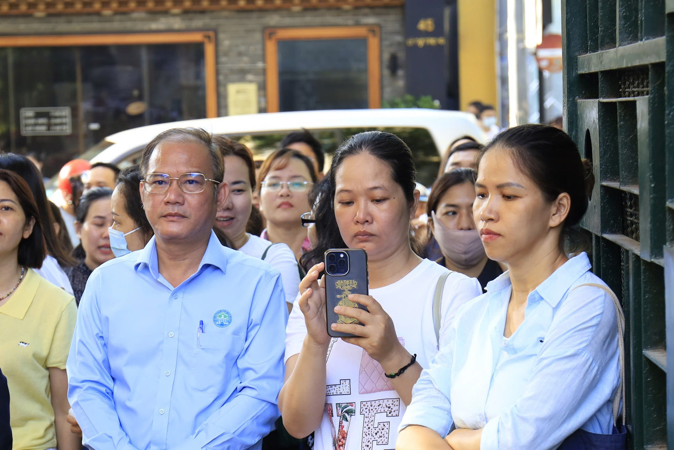 Bên ngoài điểm thi Trường THCS-THPT Trần Đại Nghĩa, nhiều phụ huynh lộ rõ nét lo lắng, hồi hộp. Nhiều người tranh thủ gọi điện thông báo tình hình với người thân ở nhà.