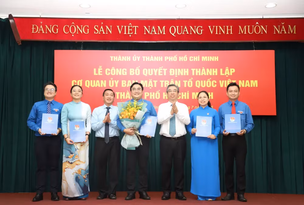 Phó Bí thư Thành ủy, Chủ tịch Ủy ban MTTQ Việt Nam TPHCM Nguyễn Phước Lộc (thứ 3 từ phải qua) cùng Phó chủ tịch HĐND TPHCM Phạm Thành Kiên trao quyết định cho anh Ngô Minh Hải (giữa) cùng các Phó Bí thư Thành Đoàn TPHCM. Ảnh: Ngô Tùng