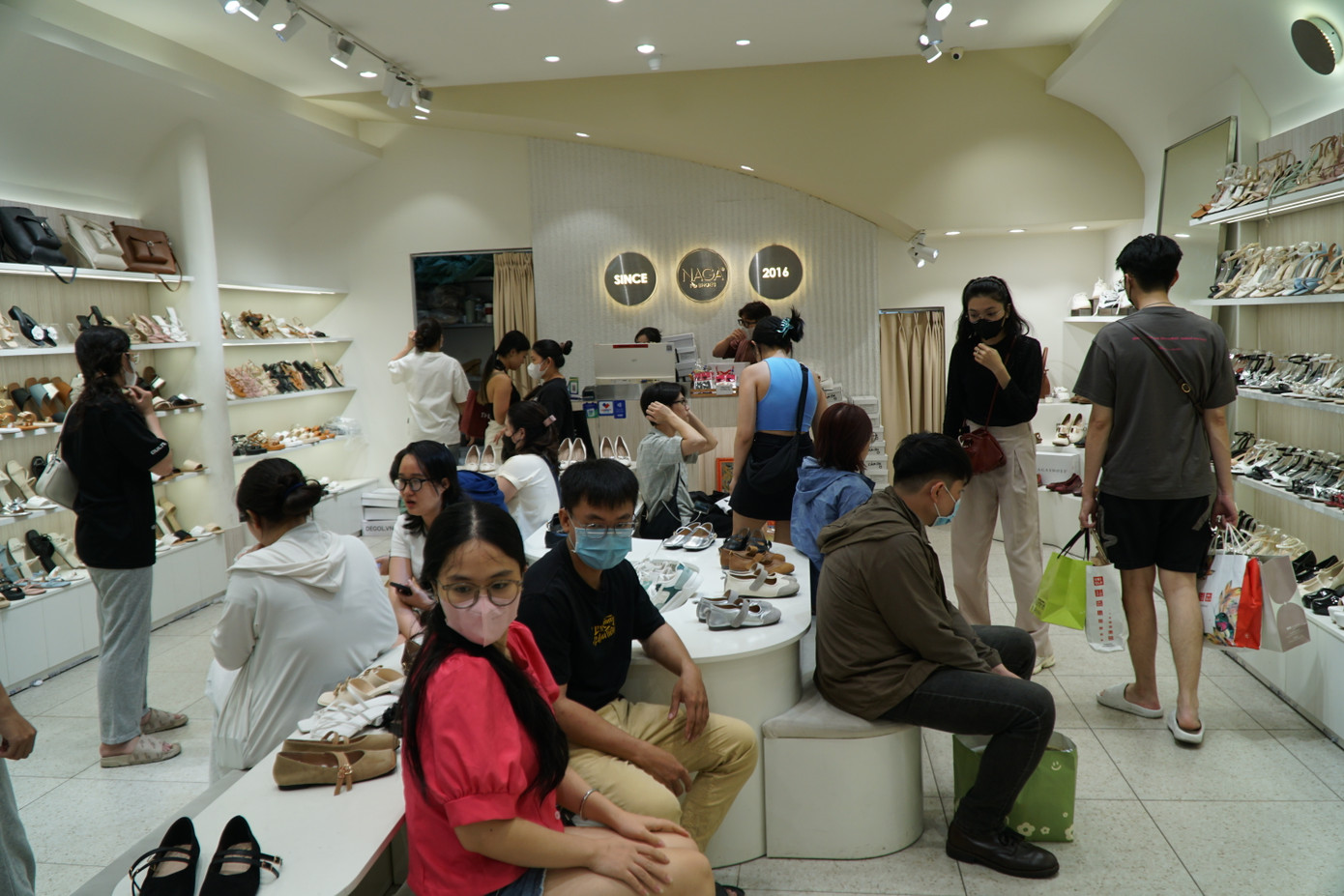 Khách lựa giày dép đông nghịt khiến nhân viên phải tất bật với công việc. Vất vả nhất là khâu lựa size cho hợp với cỡ chân khách.