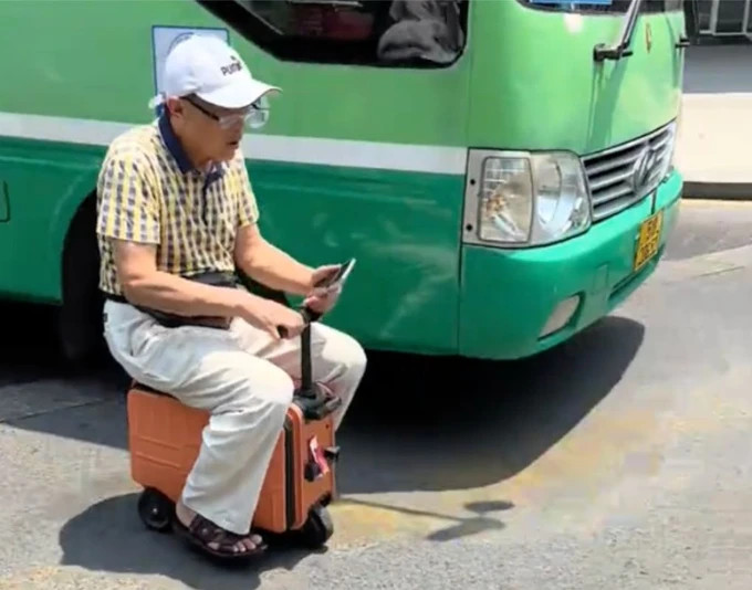 Người đàn ông 'cưỡi' vali chạy bon bon trên phố