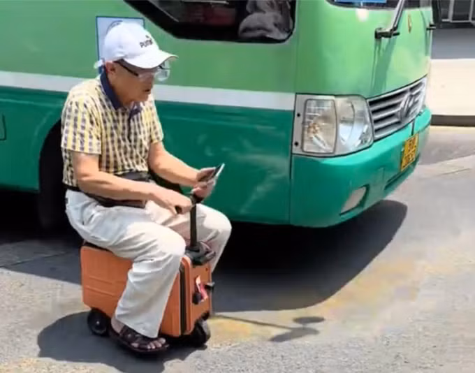 Người đàn ông 'cưỡi' vali chạy bon bon trên phố Người đàn ông 'cưỡi' vali chạy bon bon trên phố
