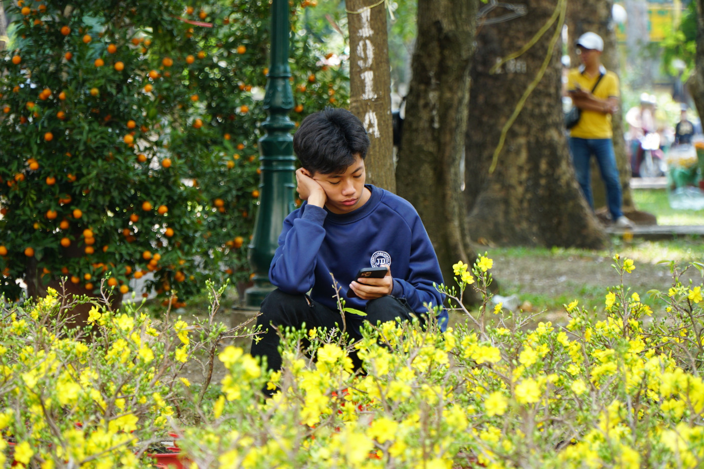 Tiểu thương ngồi chờ khách tới mua hoa trong ngày cuối cùng của năm.