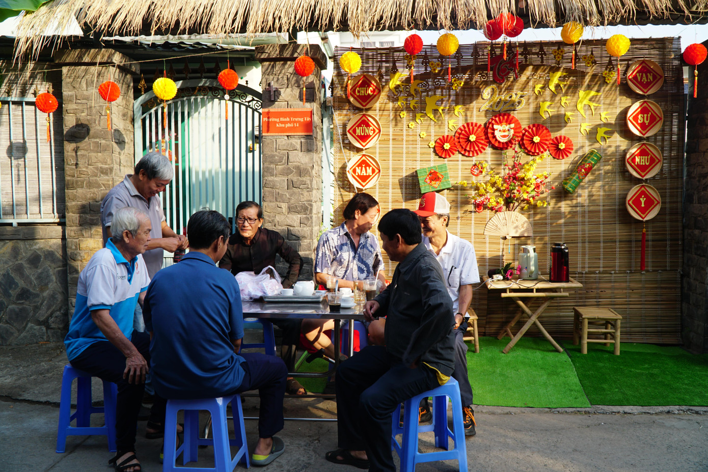 Trong ánh nắng ban mai, nhiều cụ ông hưu trí tại hẻm 26 phường Bình Trưng Tây (TP Thủ Đức, TPHCM) đã cùng nhau quây quần uống cà phê, ăn sáng bên con hẻm vừa được trang hoàng lung linh.