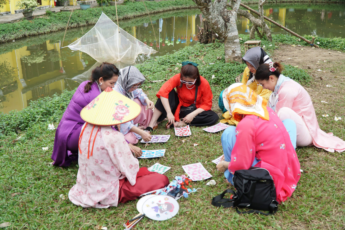 Một nhóm bạn trẻ bày chơi lô tô ngay bên cạnh hồ nước của bảo tàng.