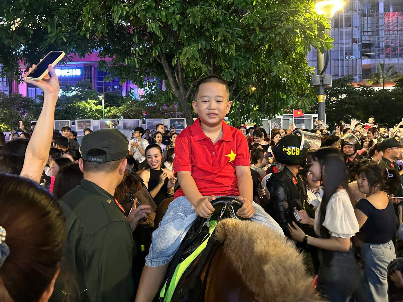 Một em nhỏ thích thú khi được các chiến sĩ cảnh sát cơ động cho ngồi thử lên kỵ binh.