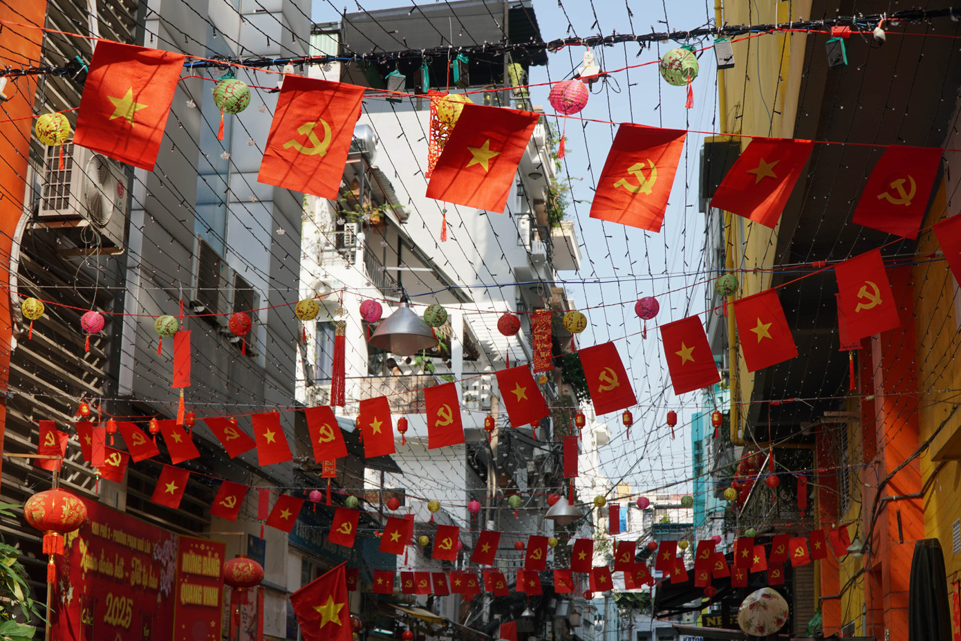 Năm nay, người dân khu phố trang trí tông màu đỏ nổi bật của cờ và đèn lồng treo xen kẽ.