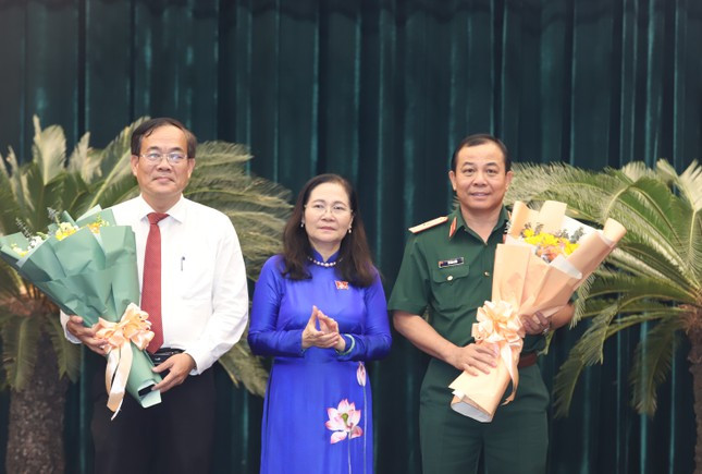 Chủ tịch HĐND TPHCM Nguyễn Thị Lệ trao hoa chúc mừng hai tân Ủy viên UBND TPHCM: Thiếu tướng Vũ Văn Điền và ông Nguyễn Duy Tân (bên trái). Ảnh: Ngô Tùng