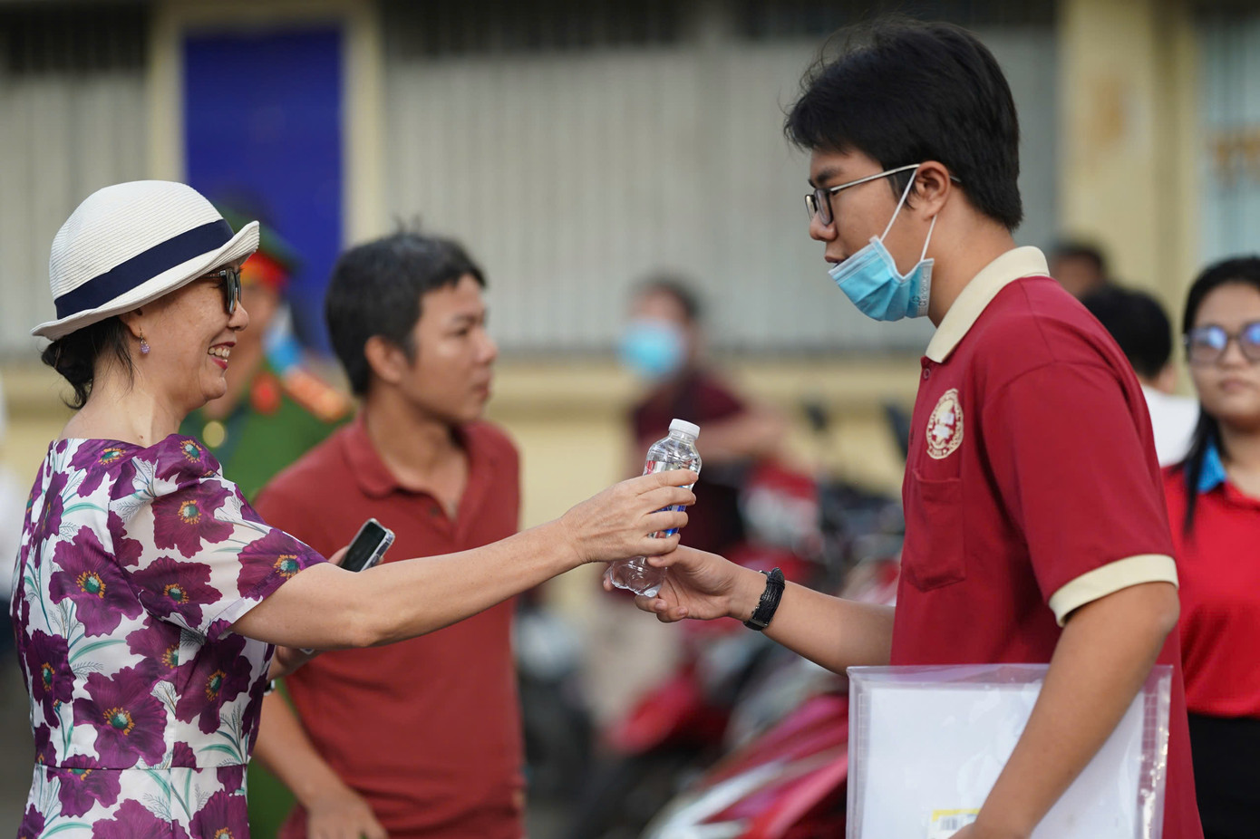 Một phụ huynh khác tiếp nước và dành nhiều lời dặn dò cho con.