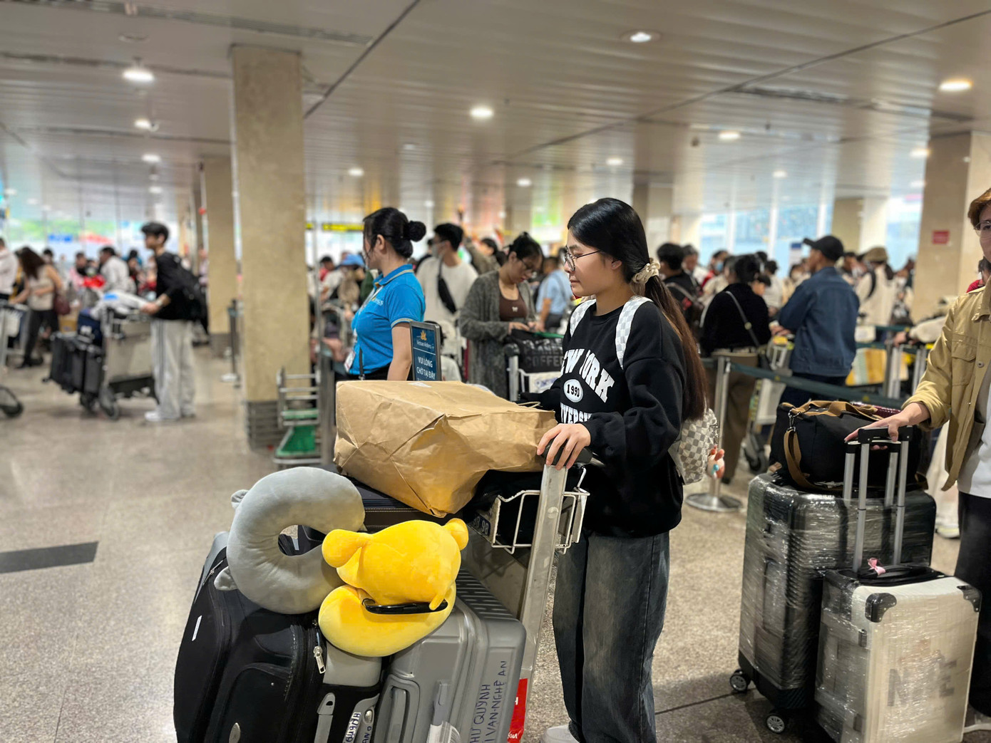 Lượng khách đông nên nhân viên sân bay được bố trí để hỗ trợ hành khách xếp hàng, làm thủ tục.