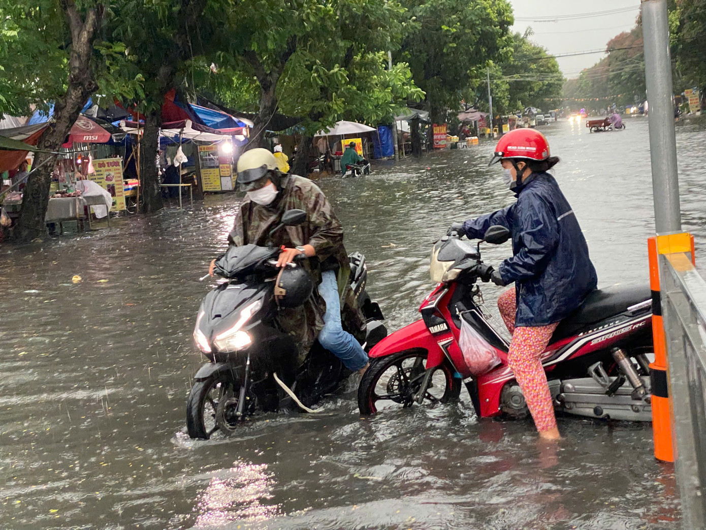 Người dân vất vả di chuyển giữa dòng nước. Một số người phải dắt xe vì chết máy giữa đường.