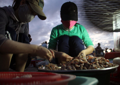 Những người làm thuê cũng thức cùng phiên chợ để phân loại tôm cá