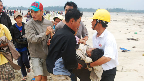 Lực lượng cứu hộ đưa nạn nhân bị chìm tàu vào bờ cấp cứu chiều 25-12 - Ảnh: Tuổi Trẻ